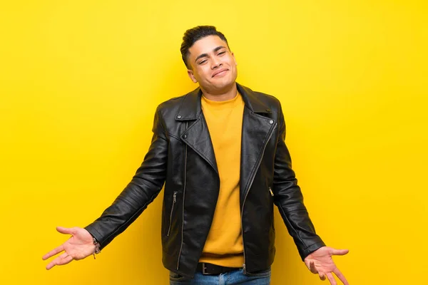 Young man over isolated yellow background smiling