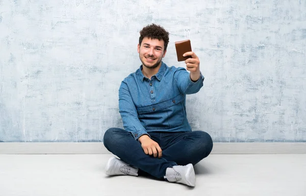 Junger Mann Sitzt Mit Geldbörse Auf Dem Boden — Stockfoto