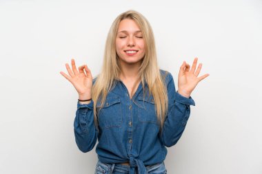 Zen poz izole beyaz duvar üzerinde genç sarışın kadın