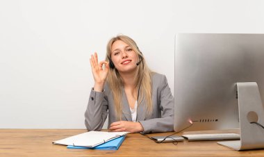 Kulaklıkla çalışan genç kadın parmaklarıyla ok işareti gösteriyor