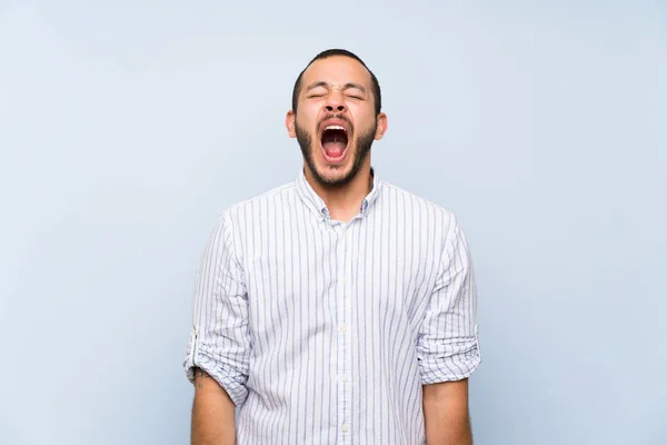 Kolumbianischer Mann Über Isolierte Blaue Wand Schreit Mit Weit Geöffnetem — Stockfoto