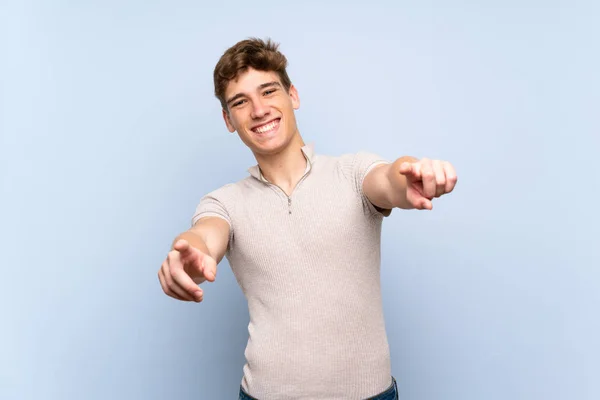 Pohledný Mladý Muž Přes Izolované Modré Zdi Ukazuje Prstem Tebe — Stock fotografie