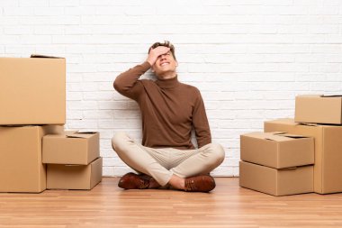 Yeni evinde kutular arasında dolaşan yakışıklı genç adam gülüyor