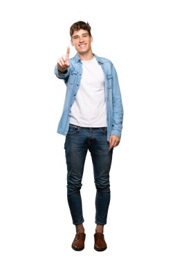 Izole beyaz arka plan üzerinde bir parmak gösteren ve kaldıran yakışıklı bir genç adam tam uzunlukta bir çekim