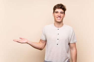 Avuç üzerinde copyspace hayali tutan izole arka plan üzerinde Yakışıklı genç adam