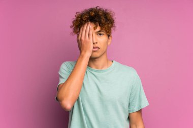 El ile bir göz kapsayan izole mor duvar üzerinde genç afrikalı Amerikalı adam