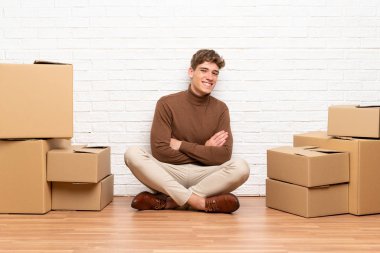 Yeni evinde kutular arasında dolaşan yakışıklı genç adam gülüyor