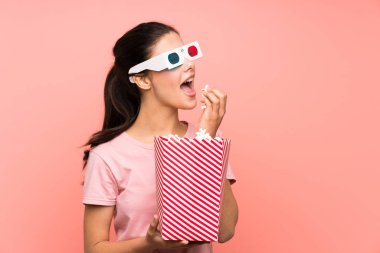 3d gözlük ile patlamış mısır yeme izole pembe duvar üzerinde Genç kız