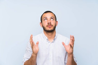 Izole mavi duvar üzerinde Kolombiyalı adam kötü bir durum tarafından sinirli