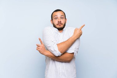 Izole mavi duvar üzerinde Kolombiyalı adam şüpheleri olan laterals işaret