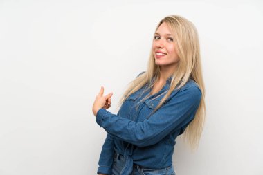 Genç Sarışın kadın üzerinde izole beyaz duvar geri işaret