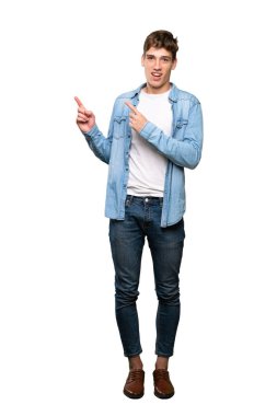 Yakışıklı bir genç adam tam uzunlukta bir çekim korkmuş ve izole beyaz arka plan üzerinde yan işaret