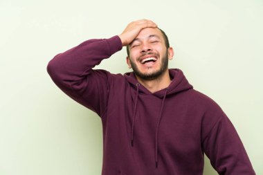 Yeşil duvara gülen Sweatshirt ile Kolombiyalı adam