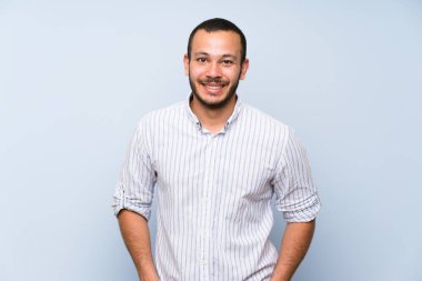 Izole mavi duvar üzerinde Kolombiyalı adam gülüyor