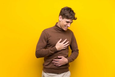 Izole sarı arka plan üzerinde Yakışıklı genç adam çok gülümsüyor