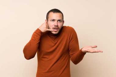 Balıkçı yaka kazak ile Kolombiyalı adam telefon jest yapma ve şüphe