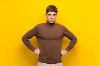 Izole sarı arka plan kızgın üzerinde Yakışıklı genç adam