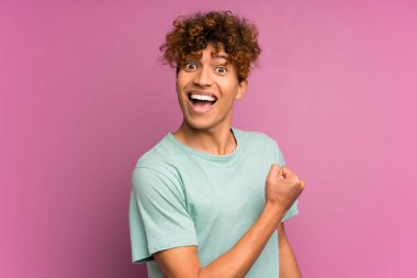 Bir zafer kutluyor izole mor duvar üzerinde genç Afrikalı Amerikalı adam
