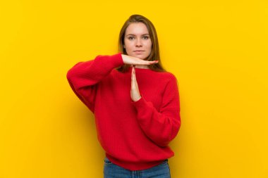 Genç kadın sarı duvar saat hareketi yapma