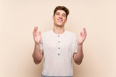 Yakışıklı genç adam üzerinde izole arka plan gülüyor