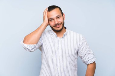 Hayal kırıklığı ve anlayış değil bir ifade ile izole mavi duvar üzerinde Kolombiyalı adam