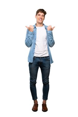 Jest kadar başparmak ve izole beyaz arka plan üzerinde gülümseyen yakışıklı bir genç adam tam uzunlukta bir çekim