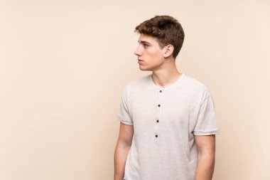 Izole arka plan üzerinde yakışıklı genç adam yan görünümlü