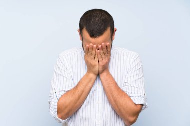 Yorgun ve hasta ifade ile izole mavi duvar üzerinde Kolombiyalı adam