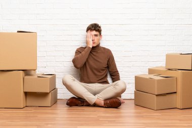 Yakışıklı genç adam elle bir göz kapsayan kutular arasında yeni evde hareket