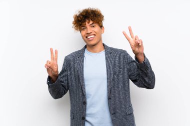 Her iki eliyle zafer işareti gösteren izole beyaz duvar üzerinde Moda afro-amerikan adam