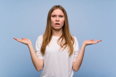 Omuzlarını kaldırırken mavi duvarın üzerinde önemsiz jest yapan genç kadın