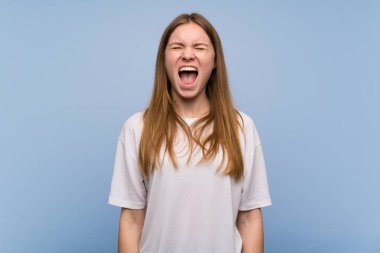 Genç kadın mavi duvar bağırarak sonuna kadar açık ağız ile ön yüzünden