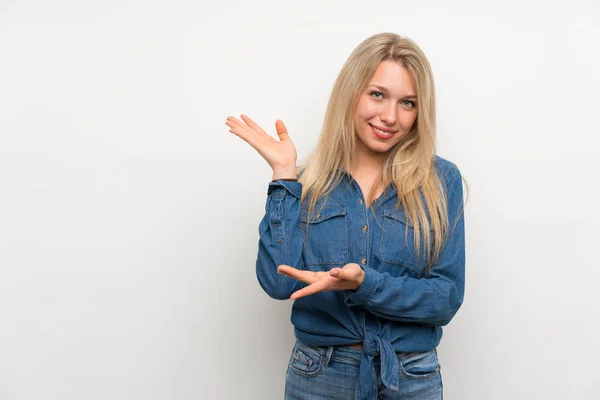 Ung Blondine Kvinde Isoleret Hvid Væg Strækker Hænderne Til Siden - Stock-foto