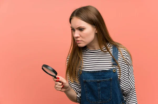 Jonge Vrouw Met Overalls Roze Muur Houden Een Vergrootglas — Stockfoto