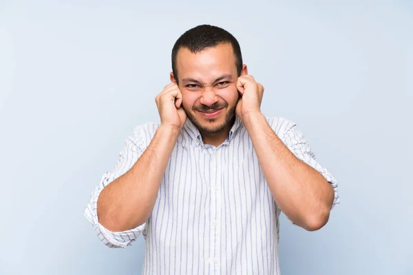 Colombiansk Man Över Isolerad Blå Vägg Frustrerad Och Täcker Öron — Stockfoto