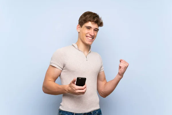 Beau Jeune Homme Sur Mur Bleu Isolé Avec Téléphone Position — Photo