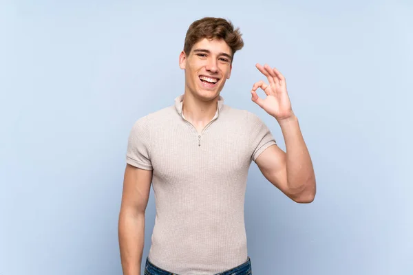 Guapo Joven Sobre Aislado Azul Pared Sorprendido Mostrando Signo — Foto de Stock