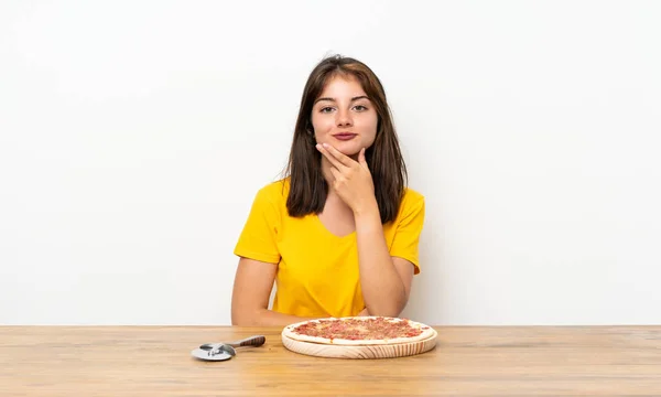 Caucasian girl with a pizza thinking an idea