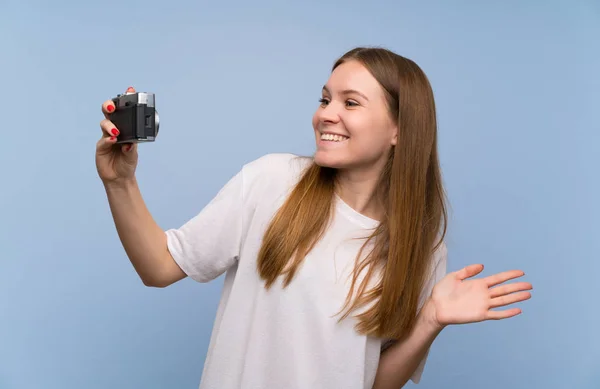 Junge Frau Über Blaue Wand Mit Kamera — Stockfoto