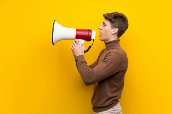 Bonito Jovem Sobre Fundo Amarelo Isolado Gritando Através Megafone — Fotografia de Stock