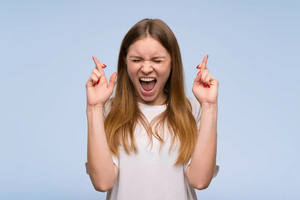 Mujer Joven Sobre Pared Azul Con Los Dedos Cruzando Deseando — Foto de Stock