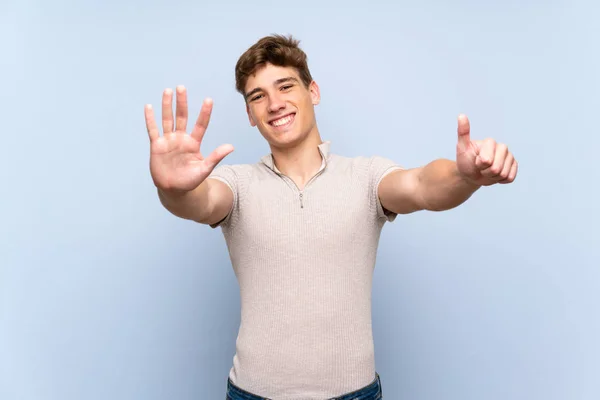 Pohledný Mladý Muž Přes Izolovanou Modrou Zeď Počítání Šest Prsty — Stock fotografie