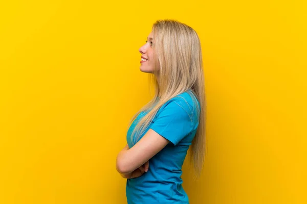 Jovem Loira Sobre Fundo Amarelo Isolado Posição Lateral — Fotografia de Stock