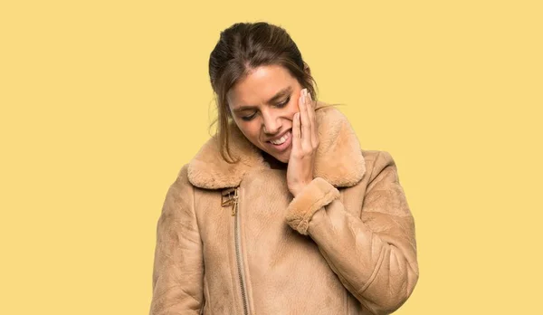 Mulher Loira Com Casaco Com Dor Dente Sobre Fundo Amarelo — Fotografia de Stock