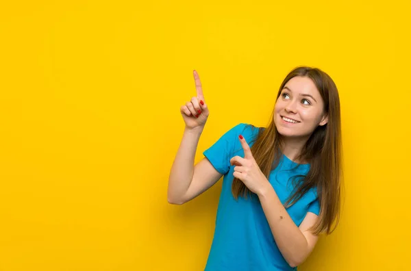 人差し指で指差す青いシャツを持つ若い女性は素晴らしいアイデア — ストック写真