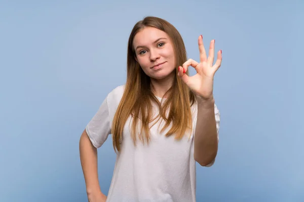 Молода Жінка Над Синьою Стіною Показуючи Знак Пальцями — стокове фото