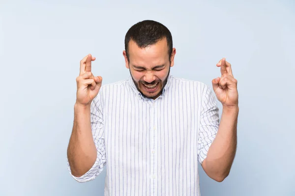 Colombian Man Isolated Blue Wall Fingers Crossing — Stock Photo, Image