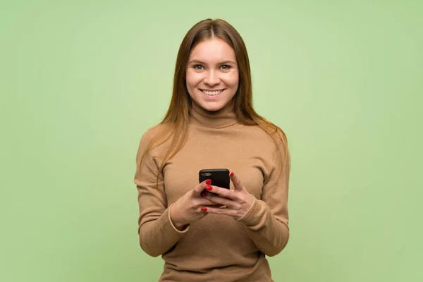 Junge Frau Mit Rollkragenpullover Sendet Eine Nachricht Mit Dem Handy — Stockfoto