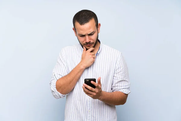 Kolumbianischer Mann Über Isolierte Blaue Wand Denkt Und Sendet Eine — Stockfoto