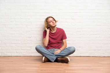 Sarışın adam yerde oturan bir fikir düşünme